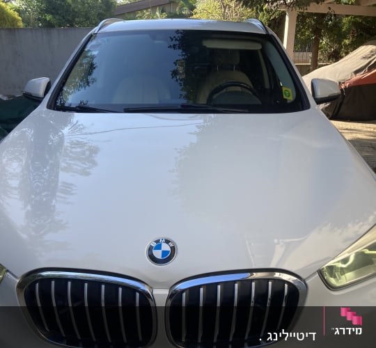 חזית רכב BMW לבן עם פנסים דולקים